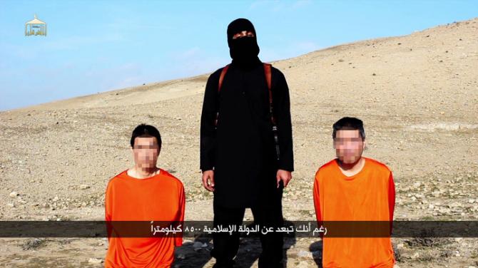 Screen grab taken on January 20, 2015 from a video reportedly released by the IS group through Al-Furqan Media allegedly shows Japanese hostages Kenji Goto (L) and Haruna Yukawa (R) with a militant as he addresses the camera in English