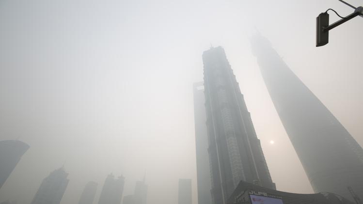 An electronic screen and buildings are seen amid heavy smog at the financial district of Pudong in Shanghai