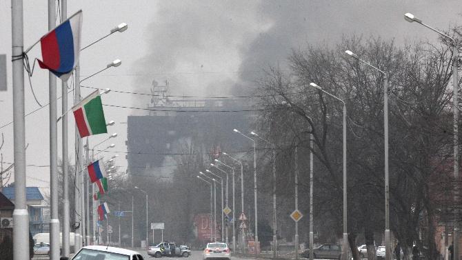 Smoke rises from a publishing house in the center of Grozny, Russia, early Thursday, Dec. 4, 2014. A gun battle broke out early Thursday in the capital of Russia&#39;s North Caucasus republic of Chechnya, leaving at least three traffic police officers and six gunmen dead, authorities said. The fighting punctured the patina of stability ensured by years of heavy-handed rule by a Kremlin-appointed leader. (AP Photo/Musa Sadulayev)