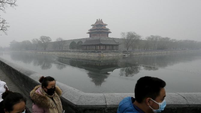 People wearing masks walk past the Turret of the Forbidden City on a heavily polluted day in Beijing Tuesday, Dec. 8, 2015. Beijing&#39;s red alerts for smog are as much about duration as they are about severity of pollution forecasts. The forecasting model must predict three or more days of smog with levels of 300 or higher on the city&#39;s air quality index - which typically would include having levels of dangerous PM 2.5 particles of about 10 times the safe level. (AP Photo/Andy Wong)