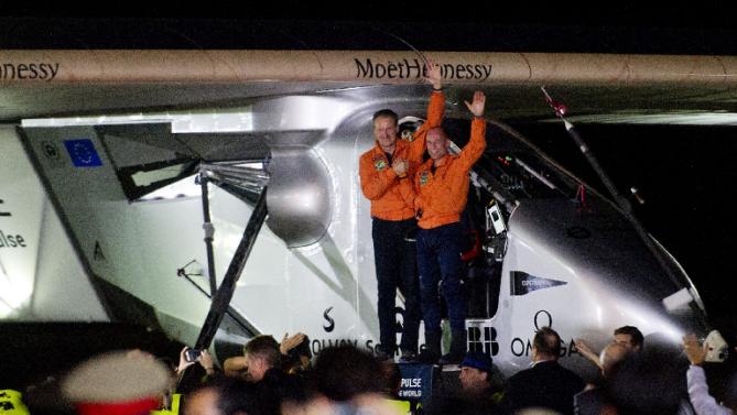 Swiss pilots Andre Borschberg (L) and Bertrand Piccard (R) wave after the Solar Impulse 2, the world&#39;s only solar-powered aircraft, landed at Mandalay international airport on March 19, 2015