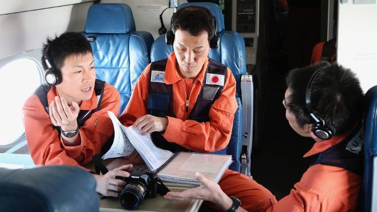 Observers on a Japan Coast Guard Gulfstream aircraft discuss their mission brief before they begin searching for wreckage and debris of missing Malaysia Airlines Flight MH370 in the Southern Indian Ocean on April 1, 2014