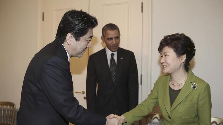 FILE - In this March 25, 2014 file photo, South Korean President Park Geun-hye, right, shakes hands with Japanese Prime Minister Shinzo Abe, left, as U.S. President Barack Obama looks on before their trilateral meeting at the U.S. Ambassador&#39;s Residence in the Hague, Netherlands. Obama’s travels through Asia this week will underscore the renewed U.S. commitment to the region, with an eye both to China’s rising assertiveness and to the fast-growing markets that are the center of gravity for global growth. (AP Photo/Yonhap, Do Kwang-hwan) KOREA OUT
