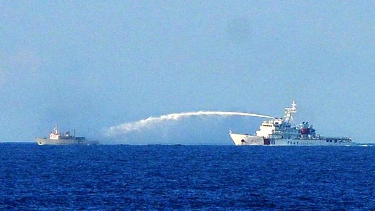 A Chinese Coast Guard ship (R) uses a water cannon to attack a Vietnamese Fisheries Surveillance boat in disputed waters of the South China Sea on June 2, 2014