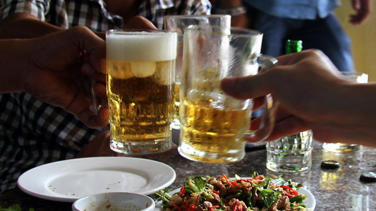 Diners enjoy a dish of cat meat while drinking beer at a restaurant in Hanoi on June 19, 2014