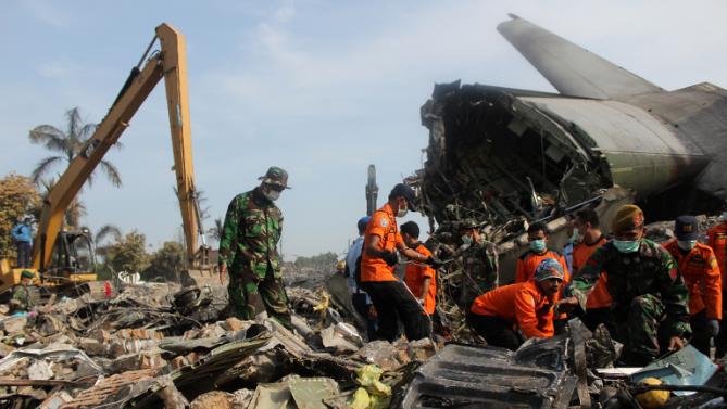 Soldiers search the tail wreckage at the crash site of an Indonesian Air Force C-130 Hercules aircraft a day after it crashed next to a destroyed commercial building in Medan, in northern Sumatra province on July 1, 2015