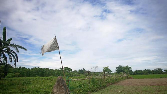 A flag on a piller indicates the border line of India and Bangladesh at Dahagram-Angarpota enclave in the Bangladeshi district of Lalmonirhat on July 31, 2015